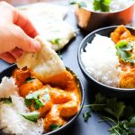 Naan dipped into butter chicken sauce
