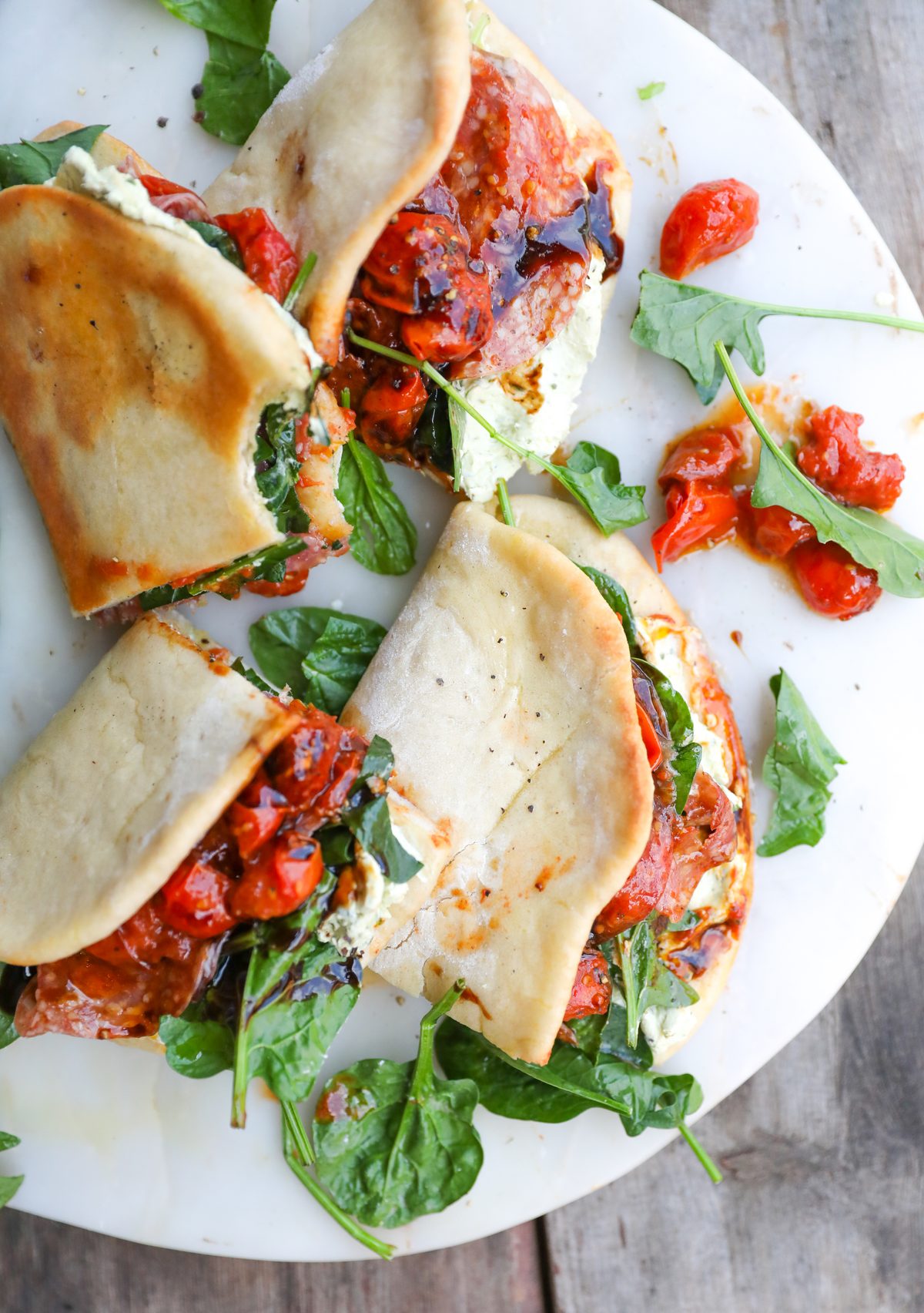 These easy homemade pizza sandwiches are made with an easy pizza dough, folded and baked until golden, then filled with creamy basil pesto, salami, baby spinach and juicy charred cherry tomatoes. Finish with a drizzle of balsamic glaze for an absolutely delicious lunch or dinner!